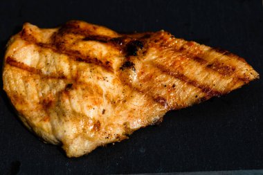 Izgara bifteği, izole edilmiş küçük siyah kesme tahtasına yakın tut. Barbekü, ızgara ve yemek konsepti.