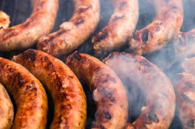 Barbekü ızgarasında ev yapımı sosislerin detaylarını kapat. Barbekü, ızgara ve yemek konsepti.