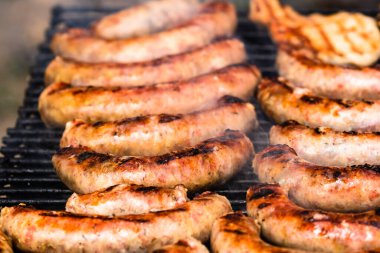 Barbekü ızgarasında ev yapımı sosislerin detaylarını kapat. Barbekü, ızgara ve yemek konsepti.