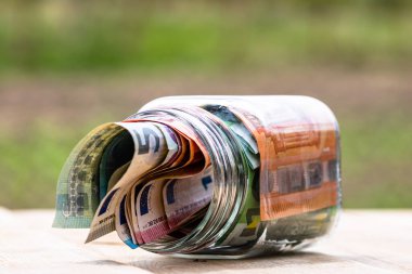 Cam bir kavanozda para biriktirme kompozisyonu. Yatırım yapma ve para tutma kavramı, tecrit edilmiş..