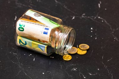 Cam bir kavanozda para biriktirme kompozisyonu. Yatırım yapma ve para tutma kavramı, tecrit edilmiş..
