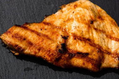 Izgara bifteği, izole edilmiş küçük siyah kesme tahtasına yakın tut. Barbekü, ızgara ve yemek konsepti.