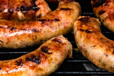 Barbekü ızgarasında ev yapımı sosislerin detaylarını kapat. Barbekü, ızgara ve yemek konsepti.