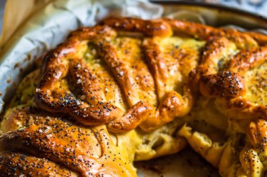 Örülmüş poğaça üzerine tuz ve haşhaş tohumlarının detaylarına odaklanmış seçici bir fotoğrafla kapat..