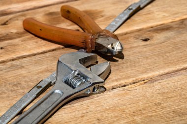 Tamir ve inşaat için aletler. Hummer, ayarlanabilir anahtar, cetvel. Kopya alanı olan rustik ahşap masadaki araçlar