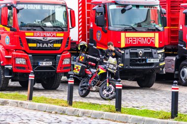 Romanya 'nın Bükreş kentindeki İçişleri Bakanlığı (İçişleri Bakanlığı) önünde park etmiş motorsikletli acil durum itfaiyecileri (Pompierii). Motosiklette SMURD acil servisi
