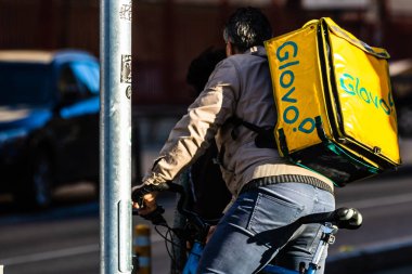 Bisikletli bir Glovo yemek kuryesi. Restoranlar kapalı ve Romanya 'nın Bükreş kentindeki Coronavirus COVID-19 salgını nedeniyle acil durum döneminde sadece teslimatlara izin veriliyor.