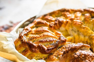 Örülmüş poğaça üzerine tuz ve haşhaş tohumlarının detaylarına odaklanmış seçici bir fotoğrafla kapat..