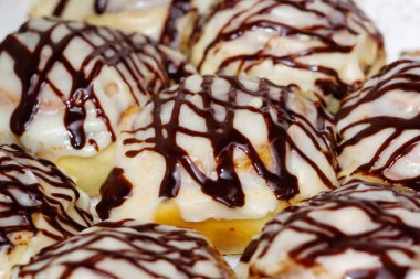 Tatlı çörekler krema ve çikolata kaplı yakın çekimler ile bulaşmış