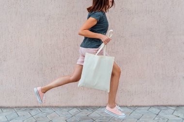 Pembe şortlu ve spor ayakkabılı kadın elinde beyaz pamukla zıplıyor..