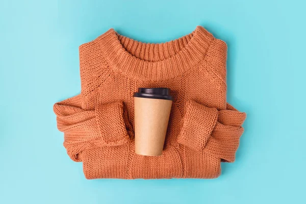 Kaffeepapierbecher auf orangefarbenem Strickpullover-Hintergrund, von oben flach liegend. Kaffeetasse zum Mitnehmen. — Stockfoto