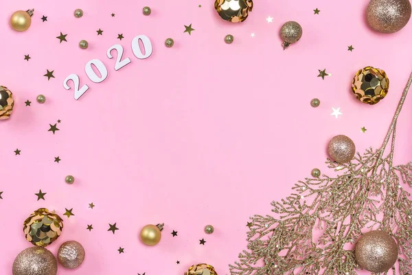 Marco navideño festivo de bolas doradas, ramas de abeto, decoraciones y confeti sobre fondo rosa pastel . —  Fotos de Stock