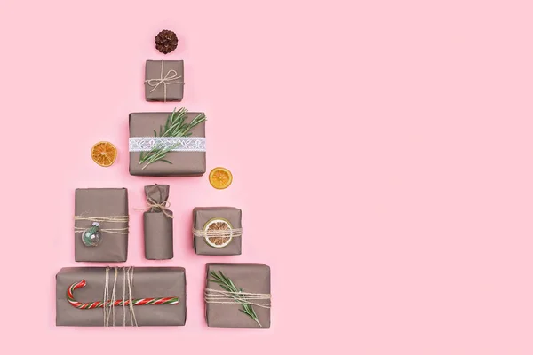 Weihnachtsbaum aus Geschenken und Geschenken in Bastelpapier verpackt. flach lag. Konzept "Ferien ohne Abfall". — Stockfoto