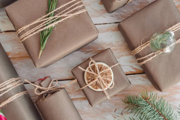 Pile de cadeaux et de cadeaux enveloppés dans du papier artisanal avec décoration sur fond blanc en bois. Couché plat, gros plan . — Photo