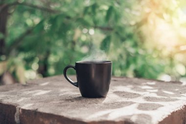 Siyah büyük fincan siyah çay, beyaz buharlı taş balkon kenarında sabah ışığında fotokopi alanı ile birlikte..