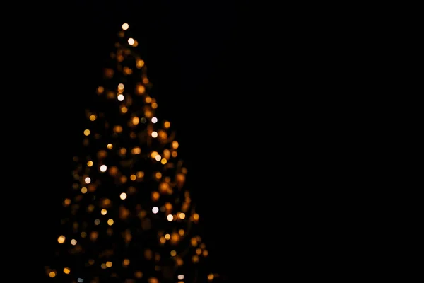Fények karácsonyfa elmosódott bokeh sötét háttér másolási hely. — Stock Fotó