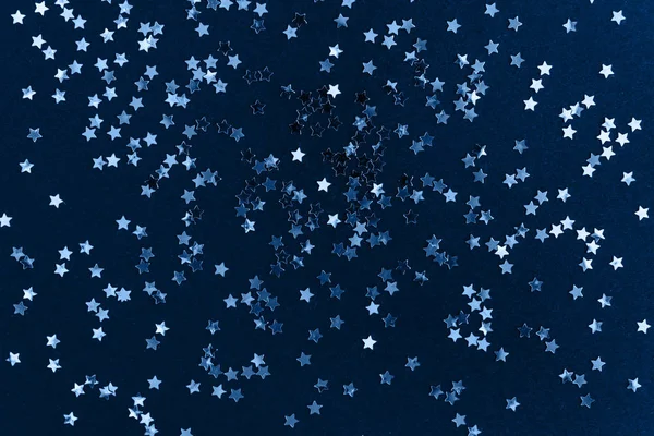 Zlatá hvězda třpytí konfety na tmavomodrém pozadí. Slavnostní sváteční zázemí. Koncept oslavy. — Stock fotografie