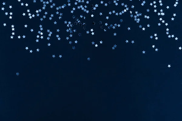 Koyu arkaplandaki yıldız simli konfeti çerçevesi mavi renkte. Bayram geçmişi. Kutlama konsepti. — Stok fotoğraf