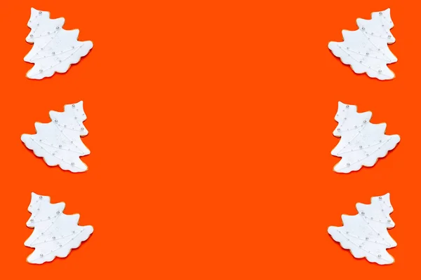 Muster aus hausgemachten Ingwerkeksen in Tannenform auf orangefarbenem Hintergrund. Weihnachtskonzept. — Stockfoto