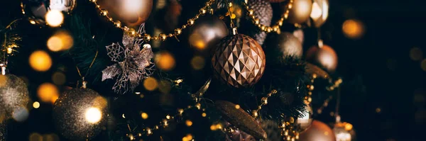 Banner met versierde kerstboom met gouden speelgoed op donkere achtergrond. Kerstconcept, 2020. — Stockfoto