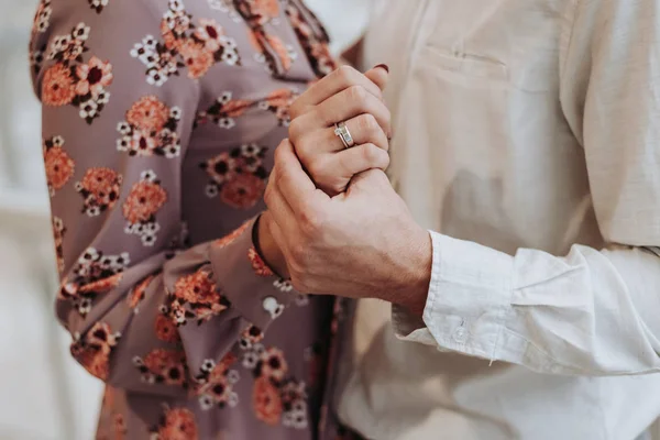 A romantic couple holding hands with wedding rings. — Stock Photo, Image