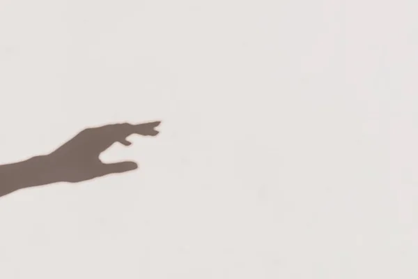 Sombras cinzentas de uma mão que alcança a parede. Efeito abstrato turvo . — Fotografia de Stock