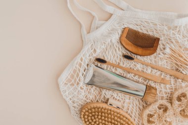 Bambu diş fırçası, diş macunu, doğal fırça, kişisel bakım kozmetik ürünleri ve soluk arkaplanda beyaz pamuk ağ torbası. Sıfır atık ve plastiksiz kavram.
