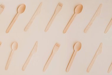 Soluk arkaplanda ahşap çevre dostu mutfak eşyaları var. Tahta kaşıklar, bıçaklar ve çatallar düz yatıyordu..