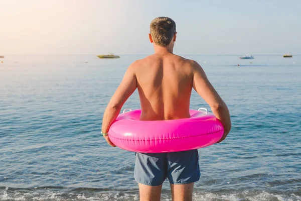 Happy Man Big Pink Inflatable Ring Sea Beach Summer Sunny lizenzfreie Stockbilder