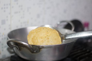 Kızarmış Puri tavada. Hindistan 'da çok popüler sokak yemekleri. Ünlü Hint yemekleri. Konuya özen gösteriyorlar.