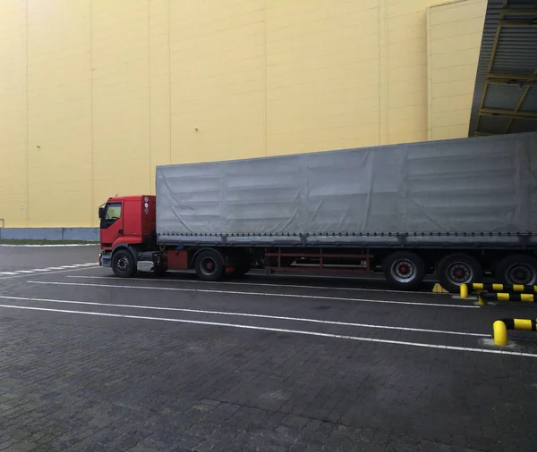 红色卡车和一辆欧洲出租车在一个装载坡道仓库。 物流运输. — 图库照片