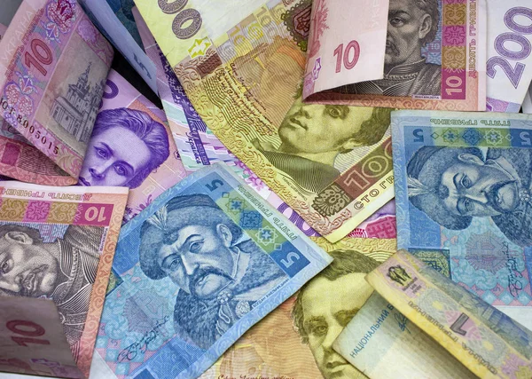 来自乌克兰钞票的背景以混乱的方式散落。 一百、二百、十、五小时的特写. — 图库照片
