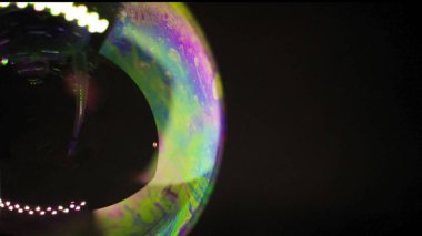 Soyutlama. Siyah arka planda suyun üzerinde sabun köpükleri. Renk oyunu. Bulanık renkli baloncuklar. Yakın plan..