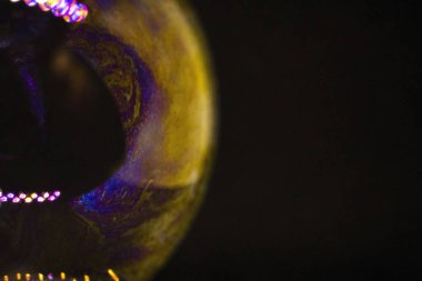 Soyutlama. Siyah arka planda suyun üzerinde sabun köpükleri. Renk oyunu. Bulanık renkli baloncuklar. Yakın plan..