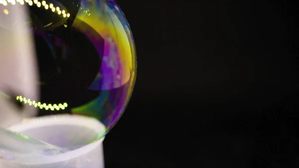 Абстракция. Мыльные пузыри на воде на черном фоне. Цветовая игра. Размытые разноцветные пузыри. Крупный план . — стоковое фото
