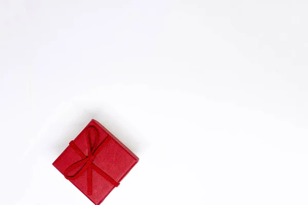 Beyaz arka planda kırmızı hediye kutusu. Kırmızı kurdele. Sevgililer günü hediyesi. Noel zamanı. İzole edilmiş. Metin için yeri olan üst görünüm.