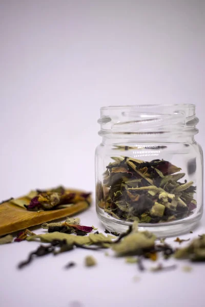 Una miscela di tè bio a base di erbe e fiori essiccati. In un vaso e alla rinfusa su uno sfondo bianco. Posto per il testo. Primo piano . — Foto Stock