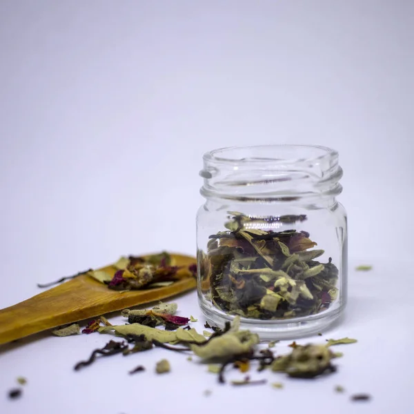 Una mezcla de bio hierbas y té seco flor. En un frasco y a granel sobre un fondo blanco. Lugar para el texto. Primer plano . — Foto de Stock