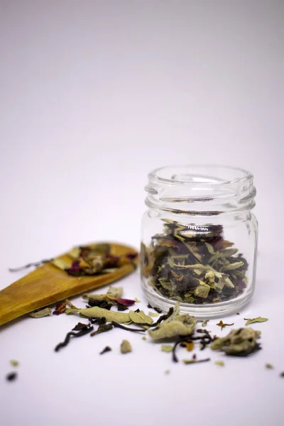 Una miscela di tè bio a base di erbe e fiori essiccati. In un vaso e alla rinfusa su uno sfondo bianco. Posto per il testo. Primo piano . — Foto Stock
