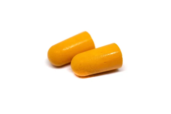 Két narancssárga füldugó fehér háttérrel. A hallás megőrzése, a zaj visszaszorítása. — Stock Fotó