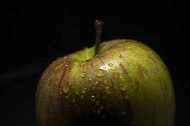 Fresh green apple closeup over black background