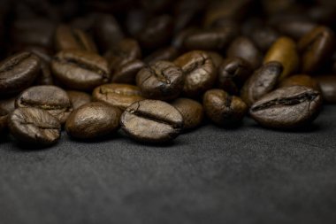Coffee in beans on dark background. Abstract background texture.Coffee beans texture. Food background of coffee beans