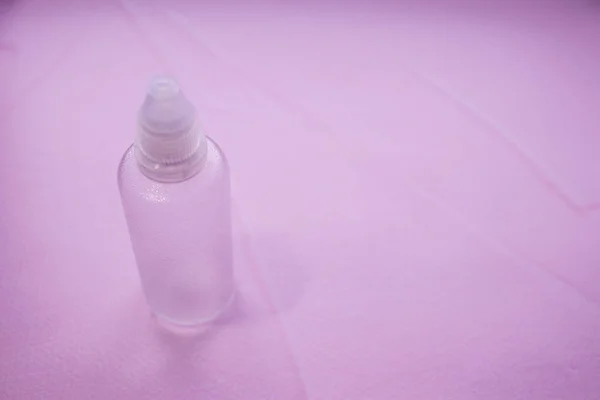 Transparent plastic packaging - a tube with a white cap, pale pink or vibrant coral background. Cosmetic container, tube. With place for your text.