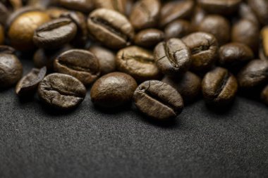 Coffee in beans on dark background. Abstract background texture.Coffee beans texture. Food background of coffee beans