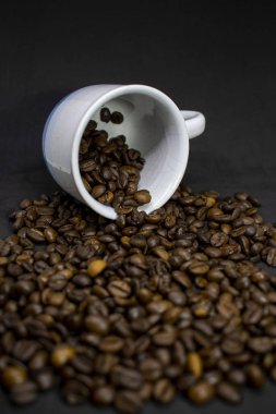 Coffee cup with grains against dark background. Close-up with copy space for your text.