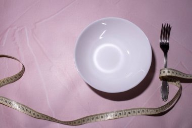 sağlıklı yeme ya da kavram diyet. boş tabak, çatal ve bıçak sarılmış bandı ölçme.