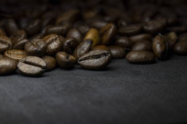 Coffee in beans on dark background. Abstract background texture.Coffee beans texture. Food background of coffee beans