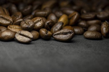 Coffee in beans on dark background. Abstract background texture.Coffee beans texture. Food background of coffee beans