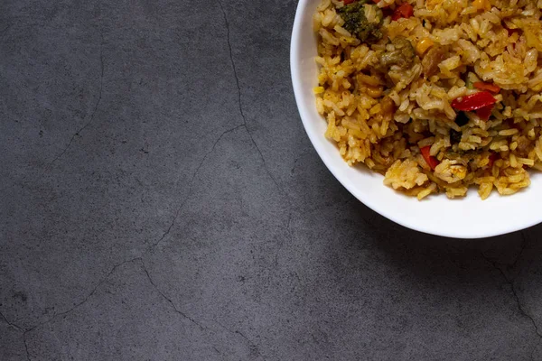 Mangkuk dalam putih besar dengan pilaf. Nasi dengan sayuran. Masakan nasional. latar belakang gelap. Tampilan atas dengan tempat untuk teks . — Stok Foto