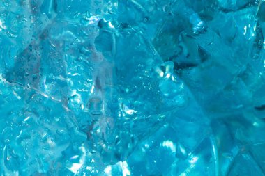 Mavi buz kristallerinin dokusu ve arkaplanı tatlı su damlalarında. Donuk, taze bir geçmiş. Klasik mavi arka plan. Dekoratif mavi bardağın makro fotoğrafı..